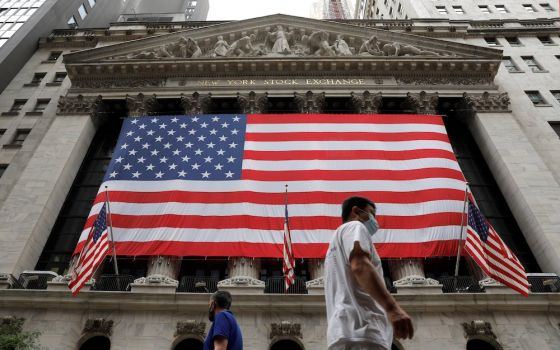 People in New York City walk by American flags Aug. 9. On Aug. 11, the Senate passed a $3.5 trillion spending package that includes immigration reform provisions, including creating a path to citizenship for 10 million people in the U.S. illegally. (CNS)