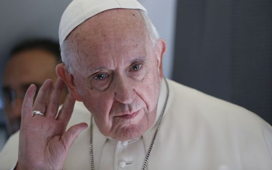 Pope Francis listens to a question while responding to journalists aboard his flight from Tallinn, Estonia, to Rome in 2018. (CNS/Paul Haring)