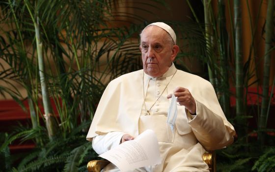 Pope Francis holds a text and his mask during the meeting, “Faith and Science: Towards COP26,” with religious leaders in the Apostolic Palace at the Vatican Oct. 4, 2021. The meeting was part of the run-up to the U.N. Climate Change Conference, called COP