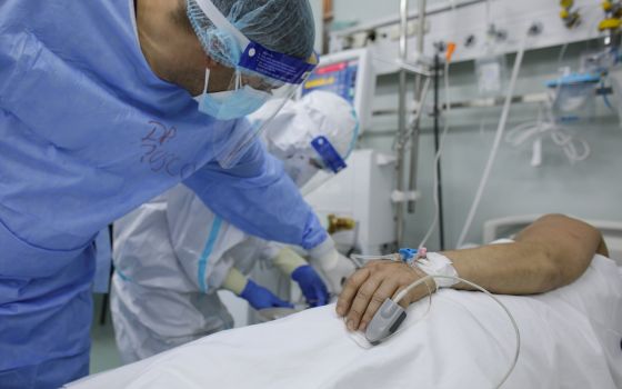 A doctor and nurse at Marius Nasta Pneumology Institute in Bucharest, Romania, take care of a coronavirus patient Oct. 17, 2021. (CNS photo/Inquam Photos, Octav Ganea via Reuters)