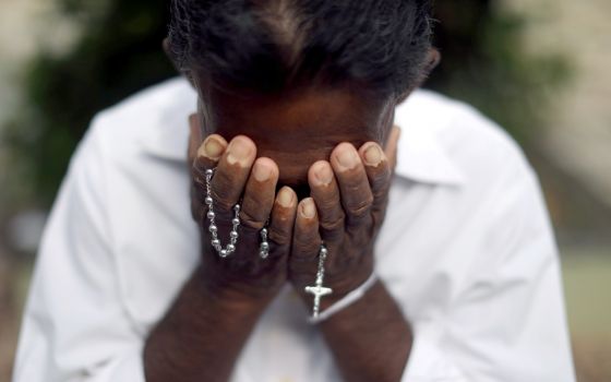 A person mourns near the grave of a suicide bombing victim at Sellakanda Catholic cemetery in Negombo, Sri Lanka, April 23, 2019. (CNS photo/Athit Perawongmetha, Reuters)