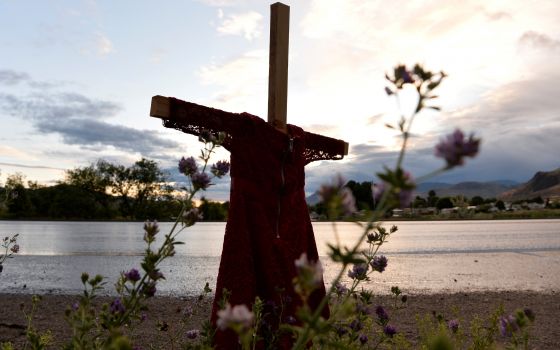 A child's red dress hangs on a stake near the grounds of the former Kamloops Indian Residential School in Kamloops, British Columbia, June 5, 2021. (CNS photo/Jennifer Gauthier, Reuters)