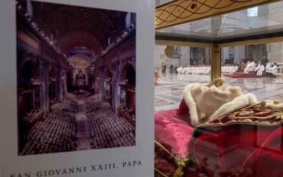 The program for the Mass celebrating the 60th anniversary of the opening of the Second Vatican Council and the feast of St. John XXIII is seen near a glass urn containing the body of the pope, who opened the council Oct. 11, 1962. (CNS/Vatican Media)