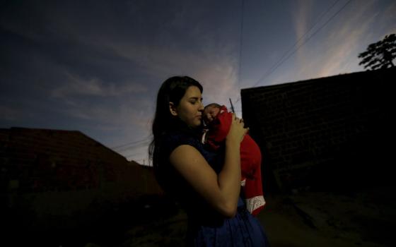 A single mother poses with her child in this 2016 file photo from Brazil.