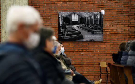 A black and white picture from March 2020 showing coffins piled up inside the church of San Giuseppe is seen on the wall of that church in Seriate, Italy, in this Feb. 28, 2021, file photo. (CNS photo/Flavio Lo Scalzo, Reuters)