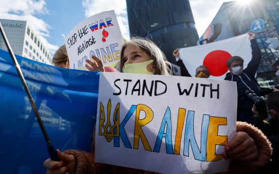 A Ukrainian residing in Japan shows a placard during a protest rally denouncing Russia over its actions in Ukraine, near the Russian Embassy in Tokyo Feb. 23, 2022. (CNS photo/Issei Kato, Reuters)