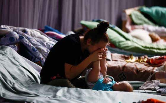   A woman plays with her child in a sports hall of a high school transformed into temporary accommodation for people fleeing the Russian war of Ukraine in Przemysl, Poland, March 9, 2022. (CNS photo/Yara Nardi, Reuters)