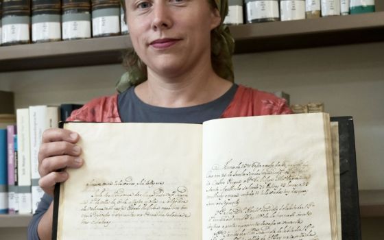 Pnina Younger, archivist at Central Archives for the History of the Jewish People at the Israel National Library, holds a rare 18th-century manuscript with details of the Portuguese Inquisition in Jerusalem July 19, 2022. (CNS photo/Debbie Hill)