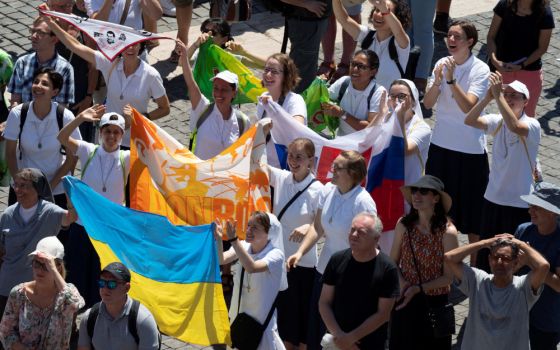 Nuns hold a Ukrainian flag as Pope Francis leads the Angelus from the window of his studio overlooking St. Peter's Square at the Vatican July 31, 2022. (CNS photo/Vatican Media via Reuters)