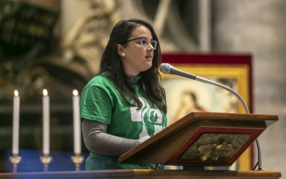 A young woman reads during Pope Francis' celebration of Mass on the feast of Christ the King in St. Peter's Basilica at the Vatican Nov. 22, 2020.