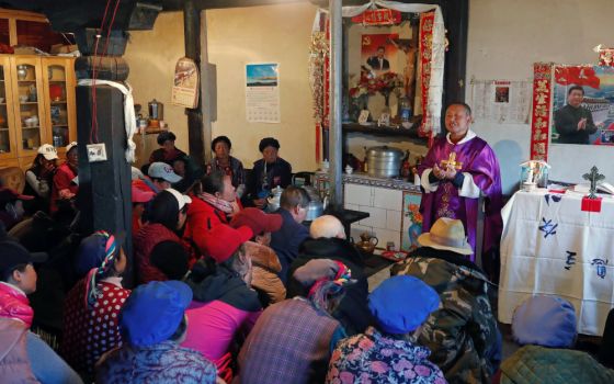 Posters of Chinese President Xi Jinping hang on the wall of the house of a Tibetan Catholic during a Mass celebrated by Father Yao Fei on Christmas Eve in Niuren village, in China's Yunnan province, in this Dec. 24, 2018, file photo. 