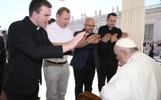 Priests pray over Pope Francis during his general audience in St. Peter's Square at the Vatican Oct. 5, 2022