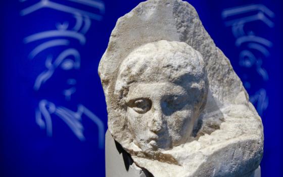 A head is carved on the surface of a white stone