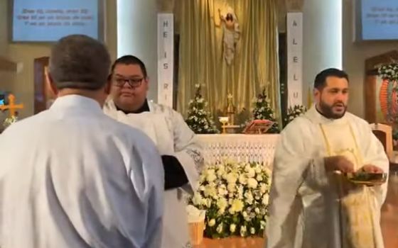 Communion is distributed during an Easter Mass April 9 at St. Emydius Church in Los Angeles County, California. The parish of 20,000 families offers 10 Sunday Masses, 9 of which are celebrated in Spanish. (NCR Photo/YouTube/St. Emydius Church)