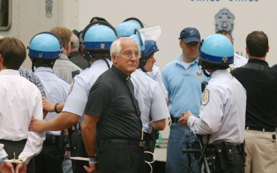 Auxiliary Bishop Thomas Gumbleton of Detroit is handcuffed during his arrest at Lafayette Park in Washington, D.C., March 26, 2003. He was among more than 60 people arrested during the war protest, sponsored by groups including Pax Christi USA and Maryknoll Global Concerns. (CNS/Bob Roller) 