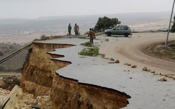 People stand in a damaged road as a powerful storm and heavy rainfall flooded hit Shahhat city, Libya, Sept. 11, 2023. At least 2,000 people have died and 10,000 are believed missing after Storm Daniel dumped so much rain on Libya’s northeast that two dams collapsed sending water flowing into already inundated areas. (OSV News/Reuters/Omar Jarhman)