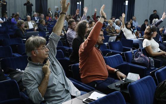 Reporters raise their hands to ask questions during a news conference after a session of the Synod of Bishops for the Amazon at the Vatican Oct. 22, 2019. (CNS/Paul Haring)