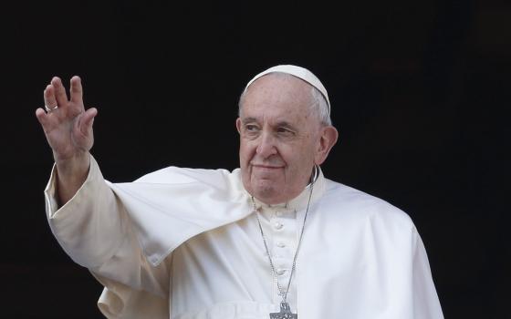 Pope Francis greets the crowd as he leads his Christmas message and his blessing "urbi et orbi" (to the city and the world) from the central balcony of St. Peter's Basilica at the Vatican Dec. 25, 2022. (CNS photo/Paul Haring)