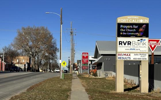 On the side of a small road, a sign says "Historic Fort Calhoun" and "Prayers for the church & our community"