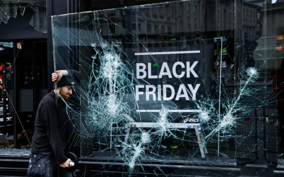 A man works to remove a broken window from a sport shop in Dublin Nov. 24, 2023, which was damaged in a night of rioting that followed a school stabbing attack Nov. 23. The school attack left three children and a teacher injured, and the rioting saw officers attacked, stores looted, public buses set on fire and 34 people arrested. The Irish language-speaking school called Cólaiste Mhuire, which means St. Mary's College, falls within the parish boundaries of St. Mary's Pro-Cathedral. (OSV News photo/Clodagh 