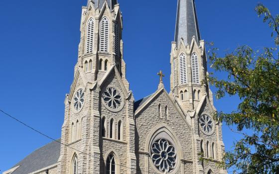 Large gothic facade looms against blue sky. 