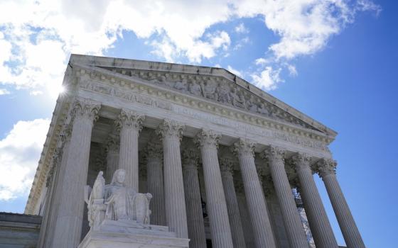 Supreme Court building looms against blue sku