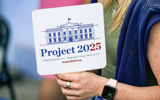 Kristen Eichamer of the Heritage Foundation holds a fan in Project 2025's tent at the Iowa State Fair, Aug. 14, 2023, in Des Moines, Iowa. (AP/Charlie Neibergall)