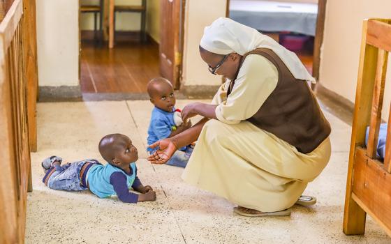 Sr. Judith Auma, a member of the Little Sisters of St. Francis of Assisi, plays with two children on Jan. 17 at St. Josephine Bakhita Babies Home in Busia, a town in western Kenya on the border with Uganda. Religious sisters are taking care of abandoned children, especially those born out of incest. (GSR photo/Doreen Ajiambo)