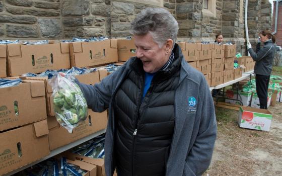 Sr. Bonnie McMenamin, a Sister of St. Joseph of Philadelphia and director of the SSJ Neighborhood Center in Camden, New Jersey, shows the bags of Brussels sprouts the center is preparing to hand out as part of its monthly food distribution day, March 20. (GSR photo/Dan Stockman)