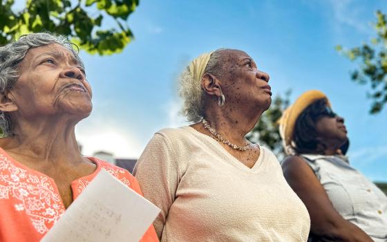 From left: Dorothy Gray, Joan Tillery and Gail Louis listen during a June 19 ceremony outside Holy Trinity Catholic Church in Washington, D.C., unveiling a plaque acknowledging "sins of racism" that took place there in the late 1800s and early 1900s that led Black parishioners to leave and establish a new parish nearby. Descendants of parishioners who left were present for a Mass and a ceremony and later spent time with modern-day Holy Trinity parishioners. (NCR photo/Rhina Guidos)