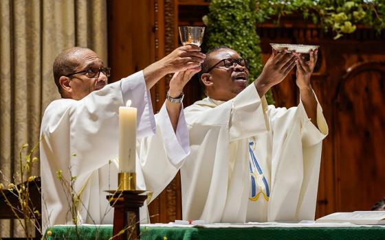 Oblate Fr. Fenelon Sylfrard, right, and Deacon Hernst Bellevue elevate the Eucharist during Sunday Mass at St. Martha Church in Uniondale, New York, in 2021. (CNS/Gregory A. Shemitz)