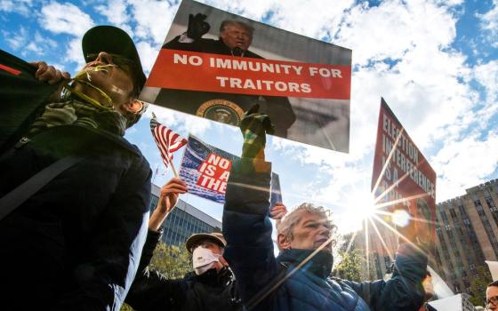 Protesters hold signs against presidential immunity