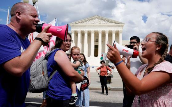 An abortion opponent and a supporter of legal abortion square off with megaphones in front of the U.S. Supreme Court in Washington June 24, 2023, the first anniversary the court's 2022 ruling in Dobbs v. Jackson Women