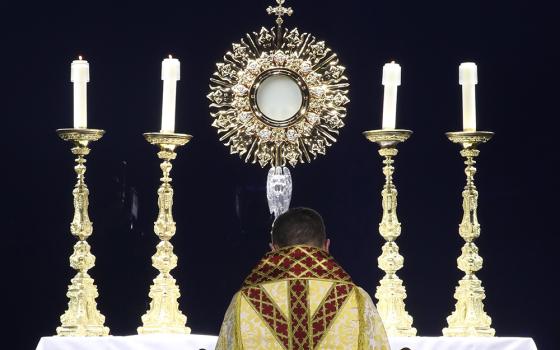 Bishop Andrew Cozzens of Crookston, Minnesota, chairman of the board of the National Eucharistic Congress Inc., kneels in prayer before the monstrance during Eucharistic adoration at the opening revival night of the 10th National Eucharistic Congress, July 17 at Lucas Oil Stadium in Indianapolis. (OSV News/Bob Roller)