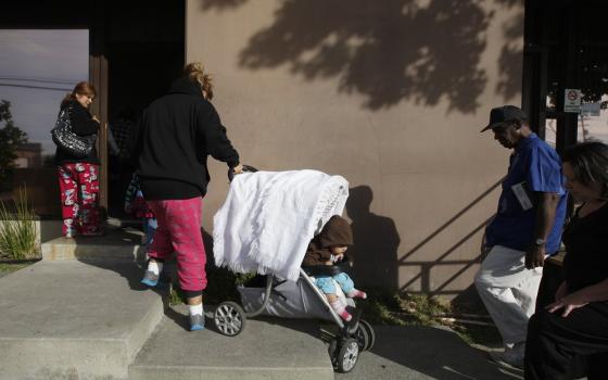 Family pulls stroller up cement stairs. 