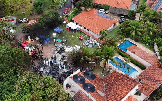 Aerial view of smoldering wreckage in middle of residential area. 