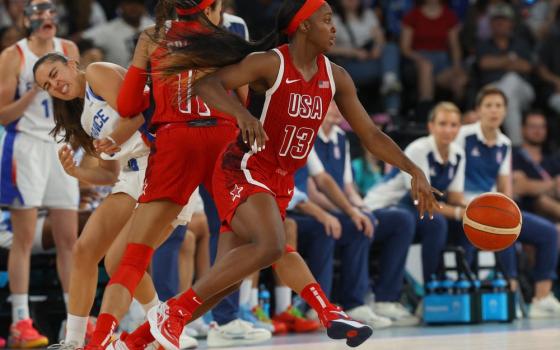 Dynamic live photo of game play, depicting Jackie Young bounding across court. 