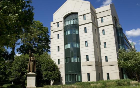 A tall, modern stone and glass building. 