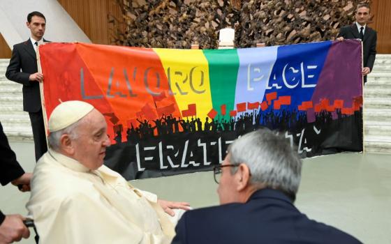 Pope Francis meets members of CGIL, Italy's largest labor union, during an audience at the Vatican Dec. 19, 2022. The banner in Italian says, "Work, Peace, Fraternity." (CNS/Vatican Media)