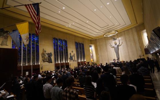 Sanctuary of Holy Family shown from rear, filled to capacity. 