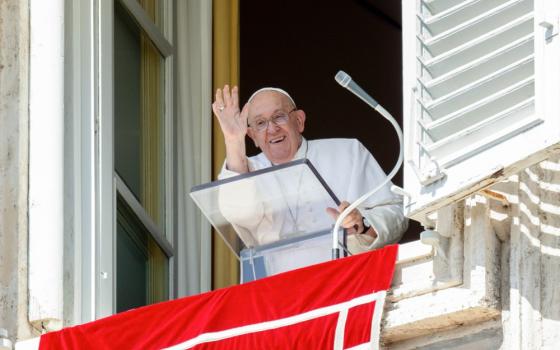 Pope waves from window. 