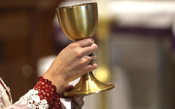 An extraordinary minister of holy Communion holds the chalice during Communion at Sacred Heart Church, Dec. 10, 2023, in Prescott, Arizona. (OSV News/Bob Roller)