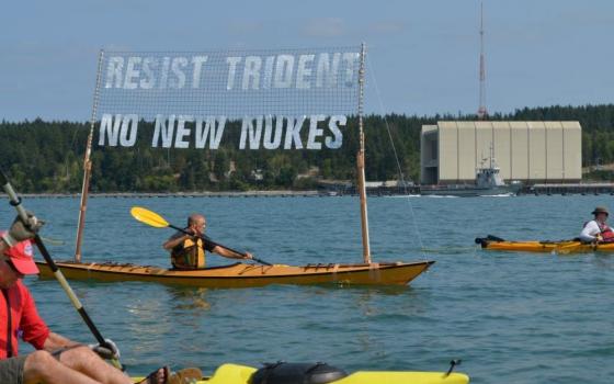 Rodney Brunell, a member of Pax Christi, participates aboard his kayak in a "peace flotilla" to protest nuclear weapons near Naval Base Kitsap-Bangor in 2016. For decades a group of activists has held peaceful demonstrations at the base, not far from downtown Seattle and home to a fleet of eight Ohio-class nuclear attack submarines. (Courtesy of Rodney Brunell)