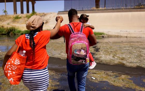 An asylum-seeking migrant family from Haiti cross the Rio Bravo to surrender to U.S Border Patrol agents to request asylum in El Paso, Texas, as seen from Ciudad Juarez, Mexico, April 22, 2022. (OSV News/Reuters/Jose Luis Gonzalez)