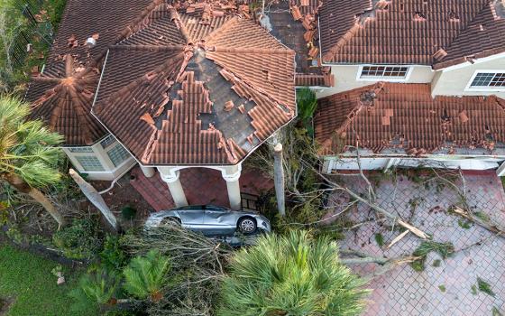 Damage is seen to a home and car Oct. 10 in Wellington, Florida, after a tornado formed by Hurricane Milton touched down striking homes in the neighborhood and surrounding area. (OSV News/USA Today Network via Reuters/Palm Beach Post/Greg Lovett)