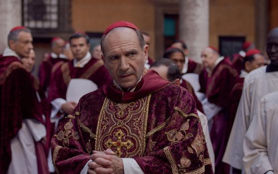 In the new film "Conclave," fictional cardinals (led by Ralph Fiennes, pictured) are tasked with selecting a new pope when the acting Holy Father suddenly dies. (Focus Features)