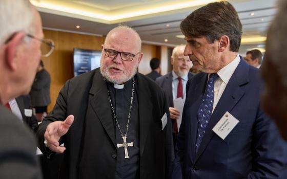 The cardinal wears plain black clerics and pectoral cross, de Franssu stands to his right wearing a navy suit.