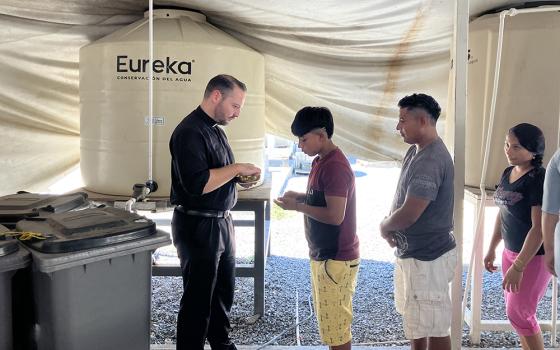 Jesuit scholastic Joseph Nolla distributes Communion during Mass celebrated Oct. 15, 2024, at the Senda de Vida migrant shelter in Reynosa, Mexico. (OSV News/David Agren)