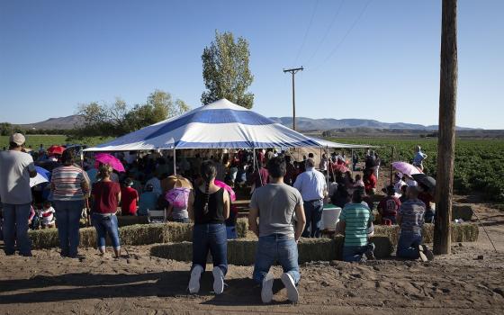 People assemble around tent.