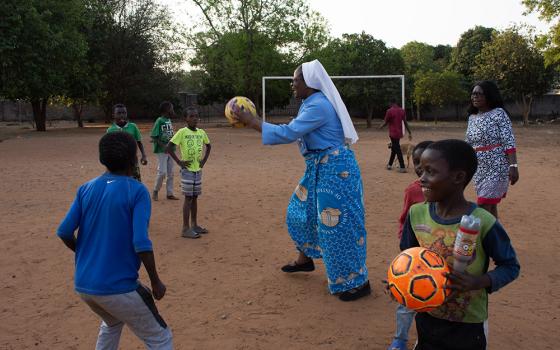 Sr. Catherine Mpolokoso, with senior staff members at Lubasi Home, joins some of the children to play some games at the facility in Livingstone, Zambia. (Derrick Silimina)